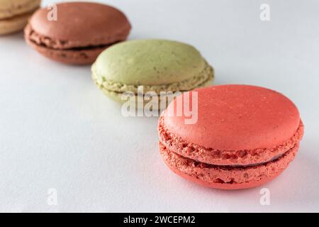 Köstliche bunte Makronen auf weißem Hintergrund. Stockfoto