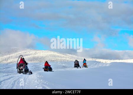 Eine Gruppe von Menschen auf einem Schneemobil in einem Berggebiet mit Schneemobile auf dem Schnee in den Bergen Stockfoto