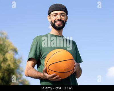 Porträt eines jungen Millennials mit Basketball in der Hand in einer Stadt Stockfoto