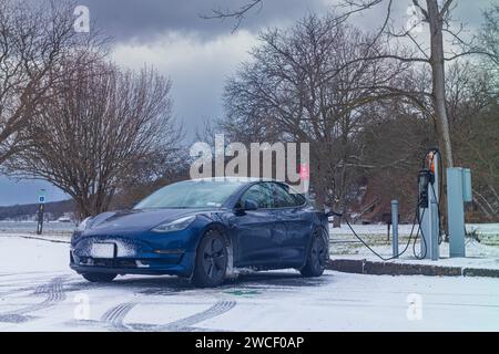 Trumansburg, NY, USA - 14. Januar 2023: Ein Tesla Model 3 lädt während eines kalten Januars an einer ChargePoint-Station der Stufe 2 im Taughannock Falls State Park auf Stockfoto