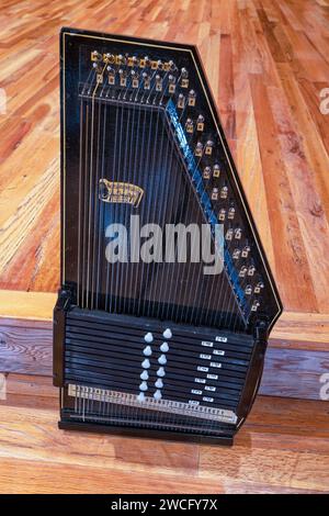 Eine schwarze Vintage-Autoharp mit 12 Akkorden auf einem Holzboden in Oregon, USA Stockfoto