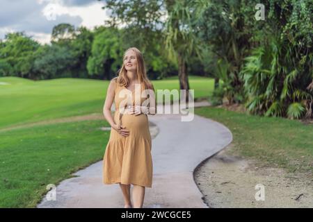 Ruhige Szene, in der eine schwangere Frau friedliche Momente im Park genießt, die Ruhe der Natur genießt und während ihrer Schwangerschaft Trost findet Stockfoto
