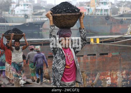 Dhaka, Bangladesch. Januar 2024. Ein Arbeiter reagiert auf die Kamera, als er auf einem Kohlegroßmarkt in Dhaka einen Kohlekorb auf seinen Kopf entlädt. (Kreditbild: © MD Mehedi Hasan/ZUMA Press Wire) NUR REDAKTIONELLE VERWENDUNG! Nicht für kommerzielle ZWECKE! Stockfoto