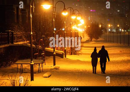 St. Petersburg, Russland. Januar 2024. Abends spazieren ein paar Spaziergänge durch eine Straßenallee mit Laternen in St. Petersburg. Quelle: SOPA Images Limited/Alamy Live News Stockfoto