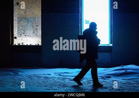 St. Petersburg, Russland. Januar 2024. Ein Mann läuft durch die Straßen von St. Petersburg am späten Abend vor dem Hintergrund einer hellen Leinwand. (Foto von Artem Priakhin/SOPA Images/SIPA USA) Credit: SIPA USA/Alamy Live News Stockfoto