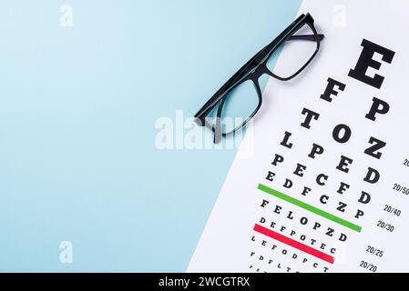Augentestkarte und Brille auf blauem Hintergrund Stockfoto