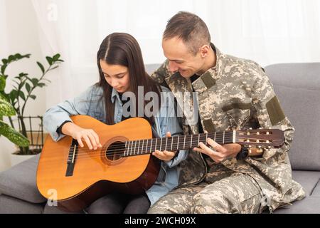 Ein Veteran und seine Tochter spielen Gitarre Stockfoto