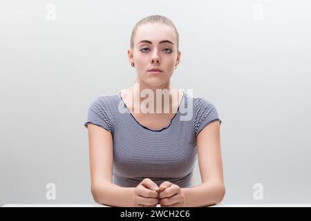 Junge Frau, die sitzt und bewundert, drückt Ruhe und entspannte Vorfreude aus. Bestimmt mit der Kraft der Ruhe und ihrer eigenen Vorbereitung. Schön. Stockfoto