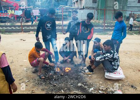 In der Kälte des Winters versammeln sich die Straßenmenschen um ein flackerndes Feuer und lauschen mit gefühlvollen Wintermelodien. Dieses Bild wurde am 13. Januar 2024 aufgenommen Stockfoto