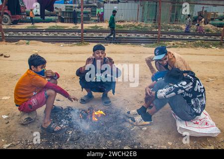 In der Kälte des Winters versammeln sich die Straßenmenschen um ein flackerndes Feuer und lauschen mit gefühlvollen Wintermelodien. Dieses Bild wurde am 13. Januar 2024 aufgenommen Stockfoto