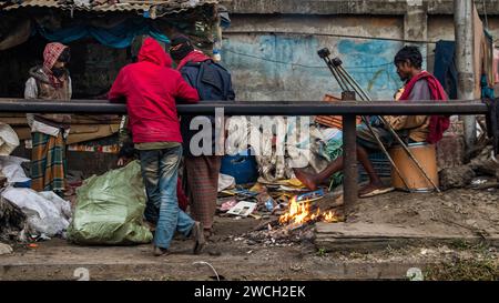 In der Kälte des Winters versammeln sich die Straßenmenschen um ein flackerndes Feuer und lauschen mit gefühlvollen Wintermelodien. Dieses Bild wurde am 13. Januar 2024 aufgenommen Stockfoto