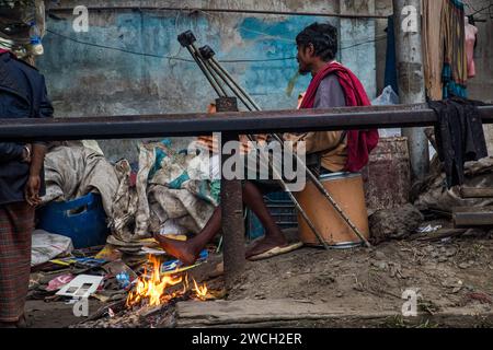 In der Kälte des Winters versammeln sich die Straßenmenschen um ein flackerndes Feuer und lauschen mit gefühlvollen Wintermelodien. Dieses Bild wurde am 13. Januar 2024 aufgenommen Stockfoto