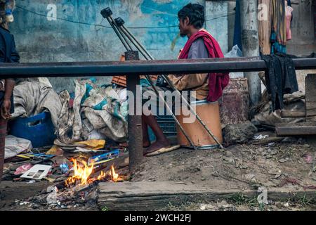 In der Kälte des Winters versammeln sich die Straßenmenschen um ein flackerndes Feuer und lauschen mit gefühlvollen Wintermelodien. Dieses Bild wurde am 13. Januar 2024 aufgenommen Stockfoto