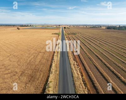 Luftaufnahme einer langen geraden Landstraße zwischen zwei trockenen Feldern bei Moolort in Central Victoria, Australien. Stockfoto