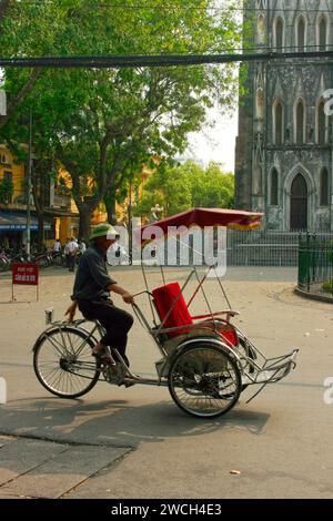 Hanoi, Vietnam - 22. April 2009: Rikscha-Fahrer wartet auf Kunden vor der St. Joseph Kathedrale in Hanoi. Stockfoto