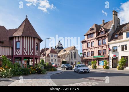 Pont-l'Évêque, Frankreich - 13. Oktober 2021: Das Tourismusbüro und die Apotheke (beide Fachwerkhäuser) und die Kirche Saint-Michel. Stockfoto