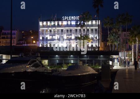 Cannes, Frankreich - 25. März 2019: Boote, die im Hafen von Cannes vor Anker liegen, mit hinter dem Hotel, das Splendid beleuchtet ist. Stockfoto