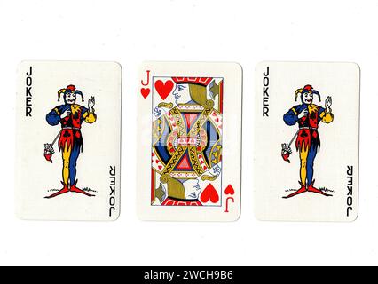 Alte Spielkarten, die ein Paar Joker und einen roten Jack auf weißem Hintergrund zeigen. Stockfoto