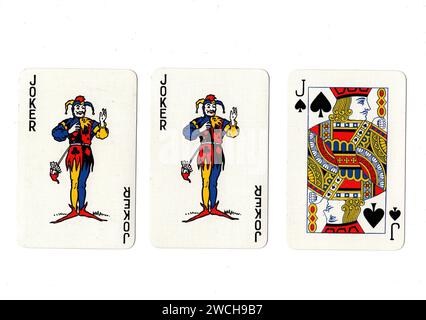 Alte Spielkarten, die ein Paar Joker und einen schwarzen Jack auf weißem Hintergrund zeigen. Stockfoto