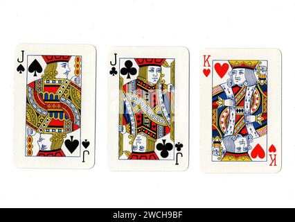 Alte Spielkarten, die ein Paar schwarze Buben und einen roten König auf weißem Hintergrund zeigen. Stockfoto