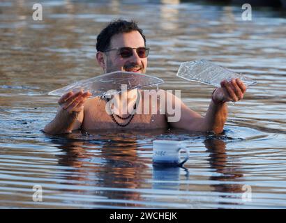 London, Großbritannien. Januar 2024. Ein Mitglied des Serpentine Swimming Clubs legt eine Tasse Tee auf dem Eis, als er Eisstücke abbricht, die den Serpentine Lake im Zentrum Londons bedeckt haben, nachdem über Nacht Temperaturen unter Null erreicht wurden. Das Met Office hat in dieser Woche gelbe Wetterwarnungen vor Eis und Schnee für große Teile Großbritanniens veröffentlicht, wobei die Temperaturen teilweise auf -10 °c sinken werden. Foto: Ben Cawthra/SIPA USA Credit: SIPA USA/Alamy Live News Stockfoto
