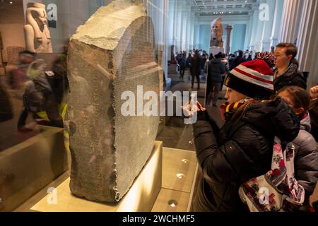 Besucher, die den Rosetta Stone im British Museum am 4. Dezember 2023 in London, Großbritannien, besichtigen. Das British Museum ist ein öffentliches Museum, das sich der Geschichte, Kunst und Kultur der Menschheit widmet und sich im Londoner Viertel Bloomsbury befindet. Sie verfügt über eine permanente Sammlung von acht Millionen Werken und gehört zu den größten und umfassendsten Sammlungen, die die Geschichte der menschlichen Kultur von ihren Anfängen bis zur Gegenwart dokumentieren. Stockfoto