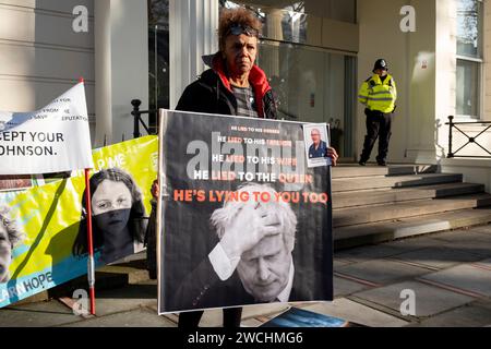 Am ersten Tag, an dem Boris Johnson an der COVID-19-Untersuchung teilnahm, protestieren Menschen vor der Tür, die am 6. Dezember 2023 in London Plakate mit dem ehemaligen Premierminister und Slogans hielten. Die COVID-19-Untersuchung des Vereinigten Königreichs ist eine unabhängige öffentliche Untersuchung der Reaktion des Vereinigten Königreichs auf die Coronavirus-Pandemie und der Auswirkungen dieser Pandemie. Stockfoto