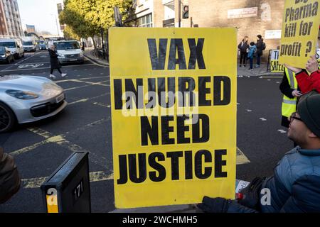Anti-vax-Demonstranten hielten gelbe Plakate mit Anti-Impfstoff-Slogans am ersten Tag, an dem der ehemalige Premierminister Boris Johnson am 6. Dezember 2023 in London, Vereinigtes Königreich, an der COVID-19-Untersuchung des Vereinigten Königreichs teilnahm. Die COVID-19-Untersuchung des Vereinigten Königreichs ist eine unabhängige öffentliche Untersuchung der Reaktion des Vereinigten Königreichs auf die Coronavirus-Pandemie und der Auswirkungen dieser Pandemie. Impfzögerungsgruppen, die als Anti-Vaxxer oder Anti-vax bezeichnet werden, sind im Allgemeinen gegen eine Impfung. Stockfoto
