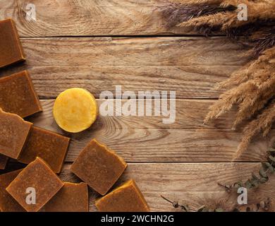 Handgemachte Bio-Seife. Seifenstangen auf Holztisch mit trockenen Blumen. Leerzeichen für Text. Bio-Kosmetik. Stockfoto