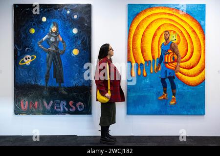 London, Großbritannien. Januar 2024. Ein Mitarbeiter mit (L) 'Universo', 2020, und 'The King (LeBron James)', 2022, beide von Federico Luger am Stand der Wizard Gallery bei der Vorschau der London Art Fair im Business Design Centre in Islington. Vom 17. Bis 21. Januar werden Werke von Künstlern aus 120 modernen und zeitgenössischen Galerien aus aller Welt gezeigt. Quelle: Stephen Chung/Alamy Live News Stockfoto