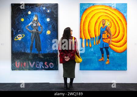 London, Großbritannien. Januar 2024. Ein Mitarbeiter mit (L) 'Universo', 2020, und 'The King (LeBron James)', 2022, beide von Federico Luger am Stand der Wizard Gallery bei der Vorschau der London Art Fair im Business Design Centre in Islington. Vom 17. Bis 21. Januar werden Werke von Künstlern aus 120 modernen und zeitgenössischen Galerien aus aller Welt gezeigt. Quelle: Stephen Chung/Alamy Live News Stockfoto