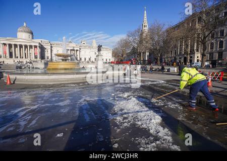 London, Großbritannien. Januar 2024. Die Arbeiter des Westminster council räumen und fegen das Eis auf dem Trafalgar Square, das sich über Nacht bildete, als die Temperaturen auf den Gefrierpunkt fielen Credit: amer ghazzal/Alamy Live News Stockfoto