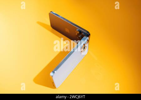Paris, Frankreich - 29. September 2023: Zwei Apple Computer iPhones iPhone 15 Pro Max und die vorherige Generation 14 Pro Max auf einem leuchtend gelben Hintergrund Stockfoto
