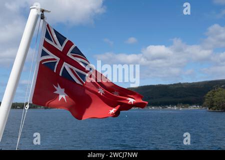 Rote Fähnchenflagge von Tasmanien mit Fliegen auf dem Achterdeck eines Bootes in Port Arthur. Eine Gastflagge ist eine Höflichkeitsflagge, die Sie in britische Gewässer einfahren Stockfoto