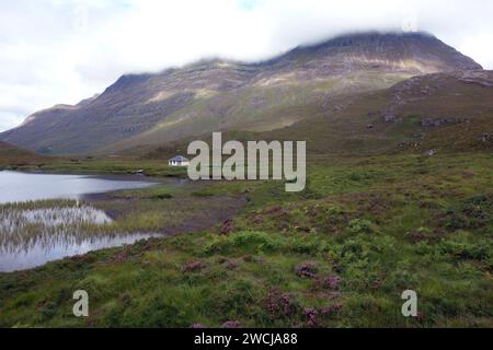 Das Boat House auf „Lochan an asgair“ in der Nähe der Munro „Liathach“ Mountain Range dahinter in Glen Torridon, Scottish Highlands, Schottland, Großbritannien. Stockfoto