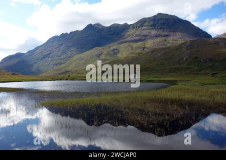 Das Boat House auf „Lochan an asgair“ in der Nähe der Munro „Liathach“ Mountain Range dahinter in Glen Torridon, Scottish Highlands, Schottland, Großbritannien. Stockfoto