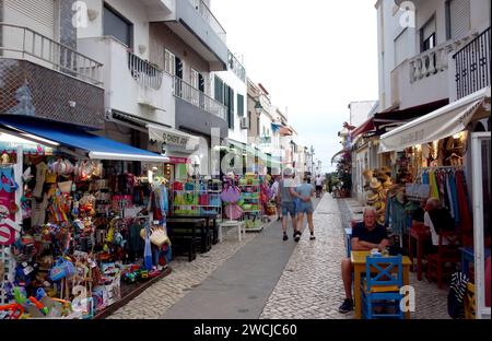 Urlauber/Touristen, die am Abend in Alvor, Algarve, Portugal, EU, auf der schmalen Rua stehen, Dr. Frederico Ramos Mendes (Straße der Bars) Stockfoto