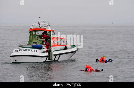 16. Januar 2024, Schleswig-Holstein, Laboe: Björn beide (Front) und Axel Stosberg, Mitglieder der norddeutschen Band Santiano und Ehrenbotschafter der Seerettler, schwimmen während einer Übung in Überlebensanzügen in der Ostsee und werden von dem Seerettungsschiff Steppke gerettet. Im vergangenen Jahr retteten deutsche Seeretter des Deutschen Seerechtsdienstes (DGzRS) bei 1938 Einsätzen in Nord- und Ostsee insgesamt 3.532 Menschen. Sie mussten allein 103 Menschen aus Seenot retten, wie die DGzRS am Dienstag mitteilte. (An die dpa'Seenotretter helfen mehr als 3.500 Menschen Stockfoto