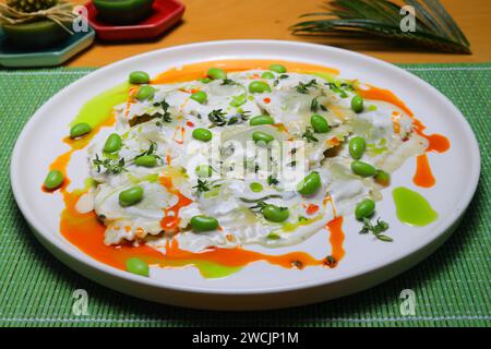 Italienische Tortellini Pasta in Sahnesauce.mit Spinat. Weißer Holzhintergrund. Draufsicht Stockfoto