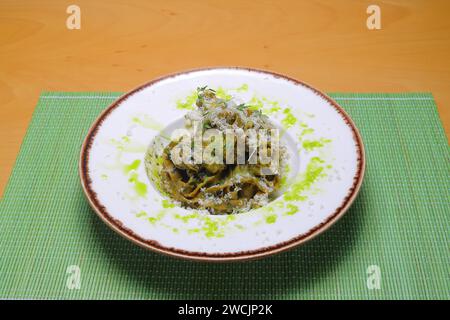 Italienische Tortellini Pasta in Sahnesauce.mit Spinat. Weißer Holzhintergrund. Draufsicht Stockfoto