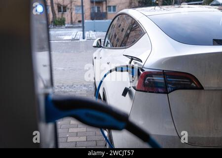 Augsburg, Bayern, Deutschland - 14. Januar 2024: Ein Tesla Model Y Elektroauto lädt an einer Ladestation für Elektroautos auf *** ein Tesla E-Auto Model Y beim Aufladen bei einer Ladesäule für Elektroautos Stockfoto