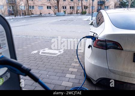 Augsburg, Bayern, Deutschland - 14. Januar 2024: Ein Tesla Model Y Elektroauto lädt an einer Ladestation für Elektroautos auf *** ein Tesla E-Auto Model Y beim Aufladen bei einer Ladesäule für Elektroautos Stockfoto