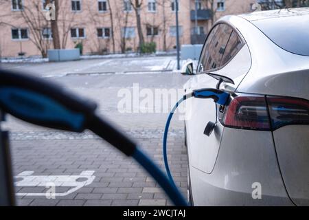 Augsburg, Bayern, Deutschland - 14. Januar 2024: Ein Tesla Model Y Elektroauto lädt an einer Ladestation für Elektroautos auf *** ein Tesla E-Auto Model Y beim Aufladen bei einer Ladesäule für Elektroautos Stockfoto