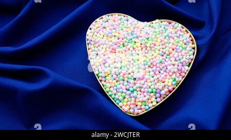 Herz voller Kugeln in vielen Farben auf blauem Hintergrund Stockfoto