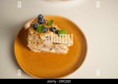 Hausgemachte Kuchen Napoleon, Millefeuille. Delikater Pudding-Kuchen, garniert mit Beeren und Minze. Auf einem grauen Betonstein Hintergrund. Stockfoto