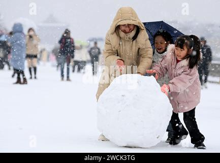 XI'an, chinesische Provinz Shaanxi. Januar 2024. Touristen spielen mit Schnee auf der schneebedeckten alten Stadtmauer in Xi'an, nordwestchinesische Provinz Shaanxi, 16. Januar 2024. Quelle: Zou Jingyi/Xinhua/Alamy Live News Stockfoto