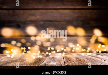 Leerer rustikaler Holztisch mit verschwommenen Glitzerlichtern Hintergrund. Weihnachtslichter auf leerem Holztisch. Hintergrundbild zu Weihnachten. Stockfoto