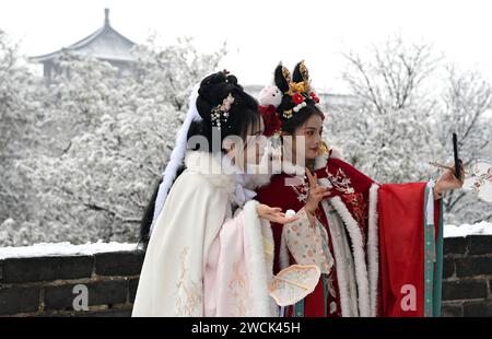 XI'an, chinesische Provinz Shaanxi. Januar 2024. Touristen machen am 16. Januar 2024 ein Selfie auf der schneebedeckten alten Stadtmauer in Xi'an, nordwestchinesischer Provinz Shaanxi. Quelle: Liu Xiao/Xinhua/Alamy Live News Stockfoto