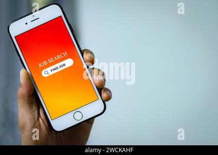 Konzept Der Jobsuche. Die Hand des Mannes hält ein Smartphone und sucht mit der App für die Stellensuche online nach Stellenangeboten. Stockfoto