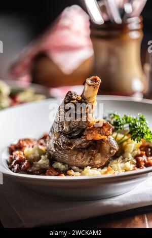 Lammkalb auf Kartoffelpüree und Backsoße konfit. Gebratene Hammelkeule mit Kartoffeln auf einem Teller in einem Restaurant. Stockfoto